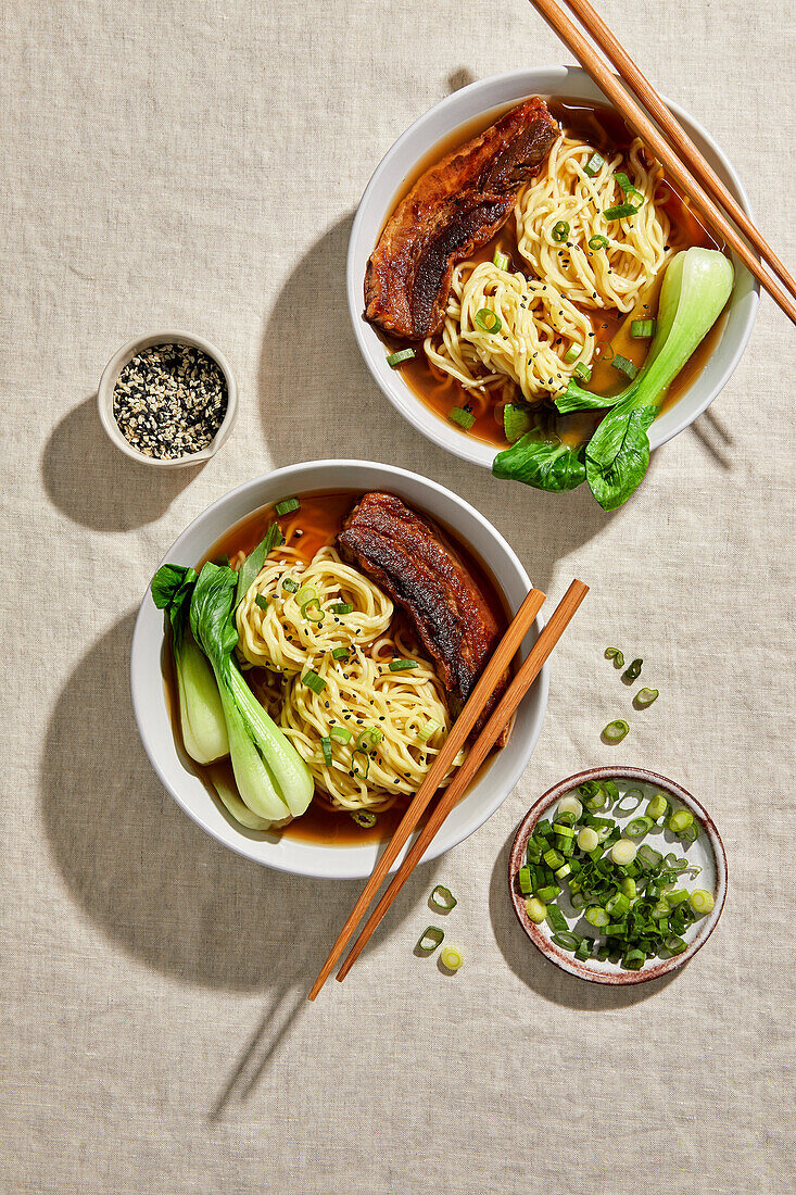 Ramen-Schweinebauch, Bok Choy und Ei vor einem hellen, neutralen Hintergrund