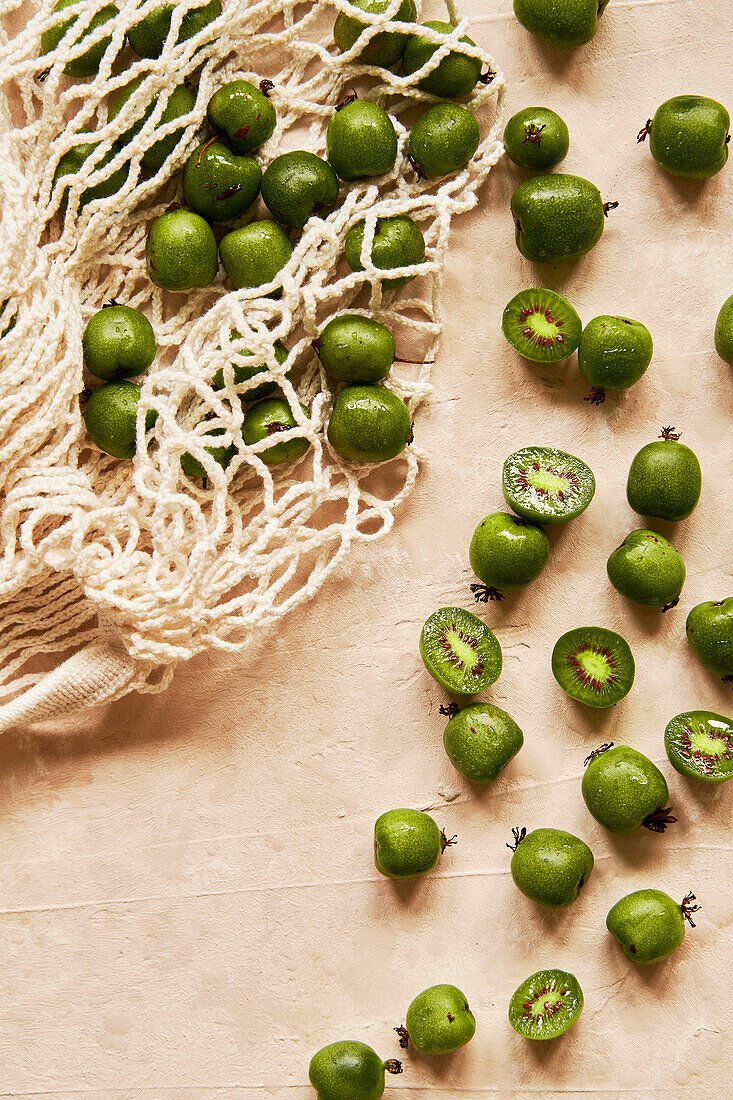 Kiwi berries on a beige background with fabric bag