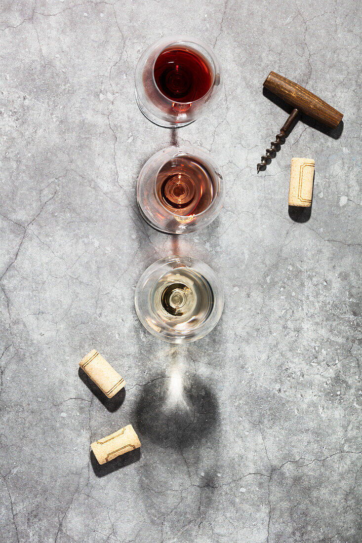 Wine composition with beautiful sunlight and shadows on a grey background. Top view, laid flat. Wine bar, winery, wine tasting concept. Minimalistic trendy photography