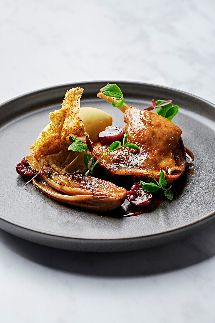 Confit duck leg, creamy puree, caramelised chicory, sour cherry jus, filo waffle dusted with pistachios