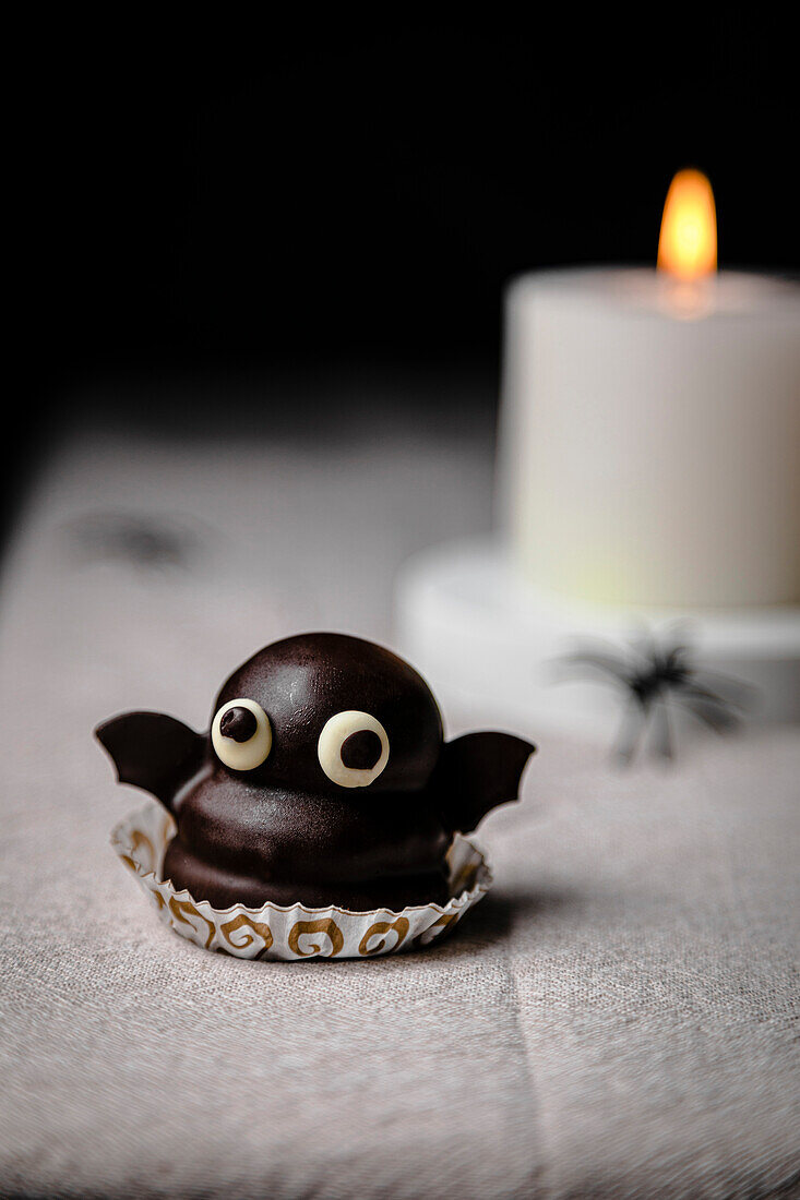 Bat candy over the table for Halloween; made from biscuits, dulce de leche and dark chocolate coating.