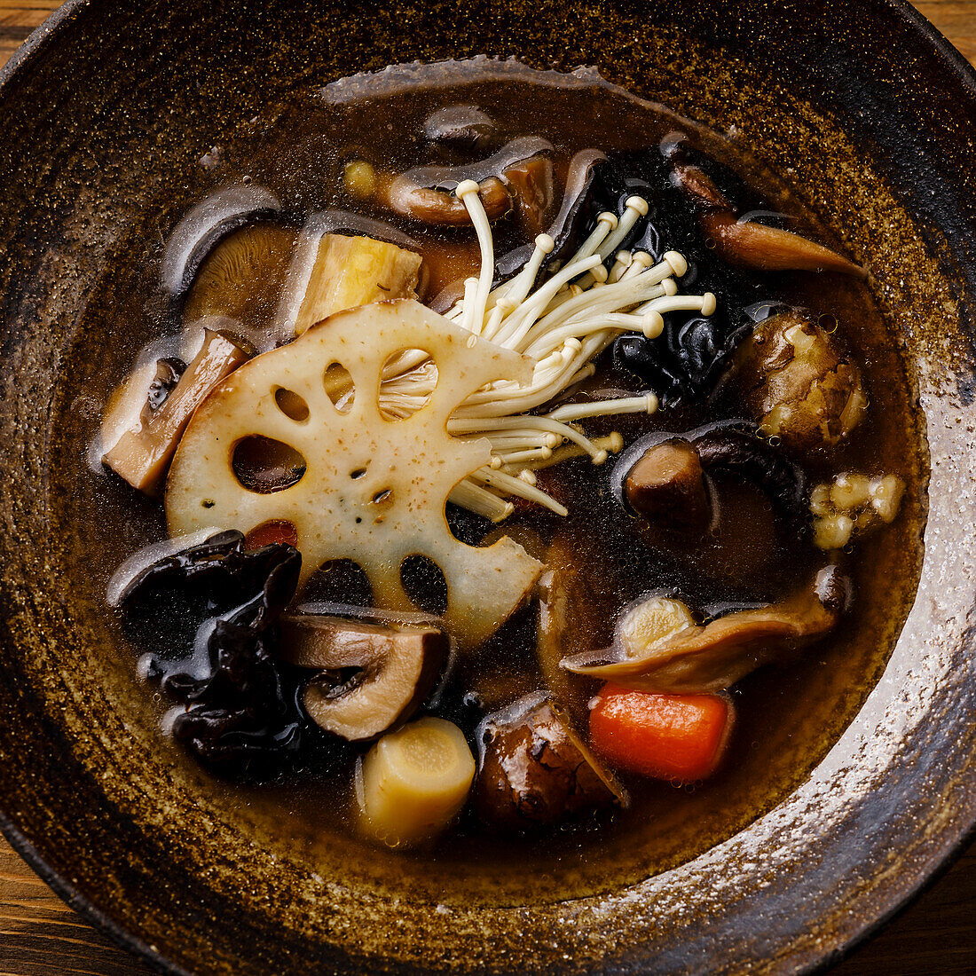 Heilende Suppe mit Wurzeln, Pilzen und Gerste auf Holztisch Hintergrund