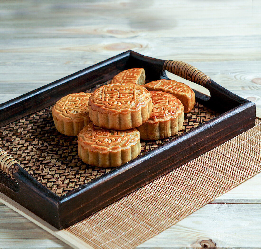 Mondkuchen zum Mittherbstfest, Konzept für traditionelles chinesisches Festtagsessen auf einem asiatischen Holztablett