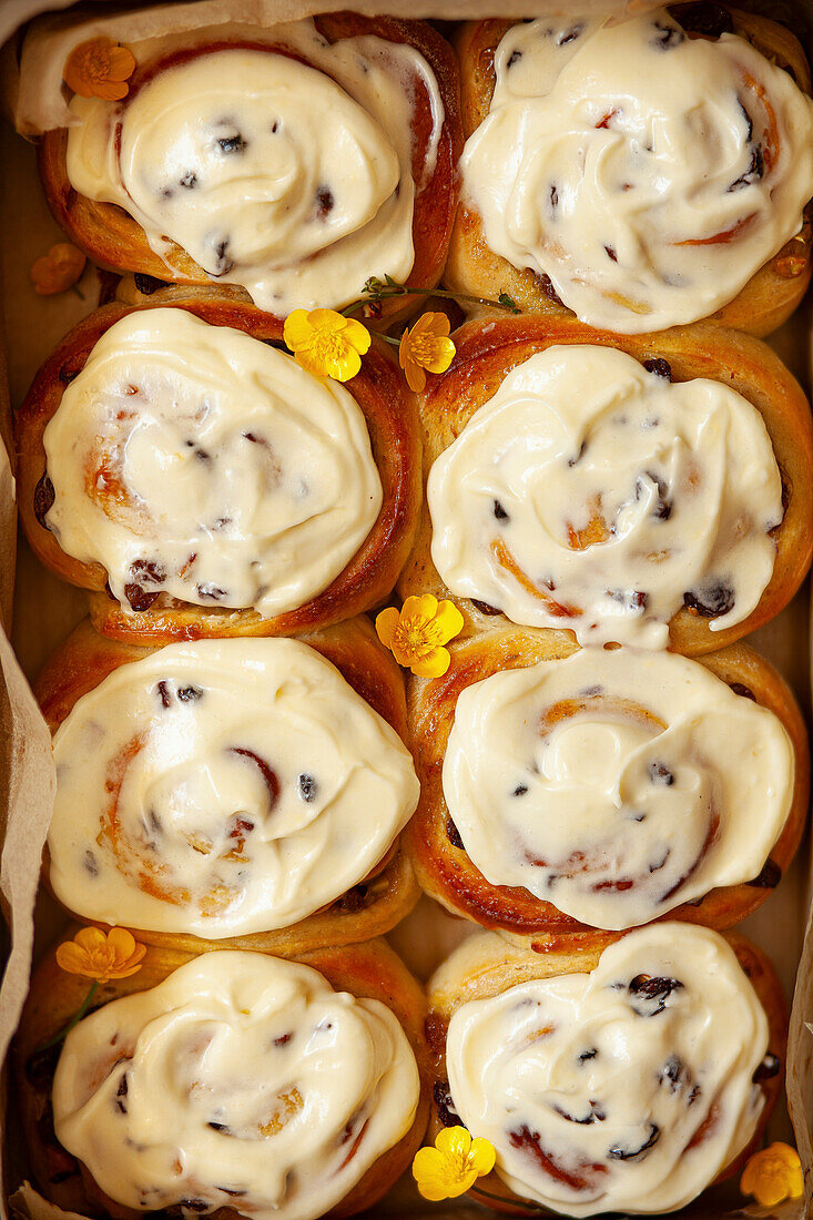 A tray with eight freshly baked lemon rolls covered with cream cheese icing