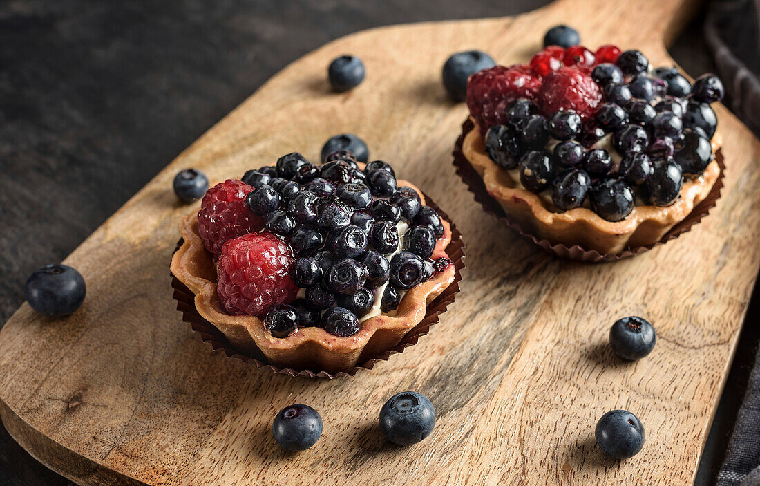 Cake basket with blueberries and raspberries. Cakes on a cutting board