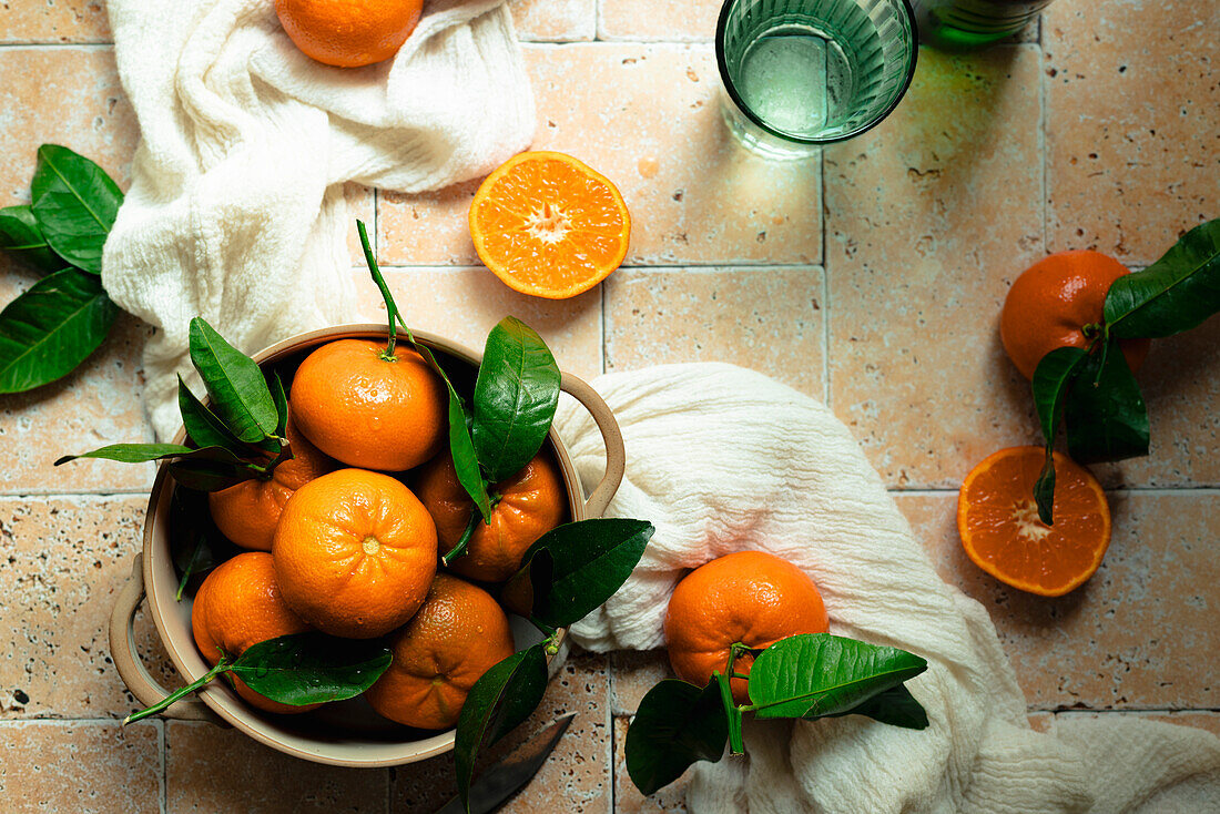 Still life of clementines in a bowl on a tiled background