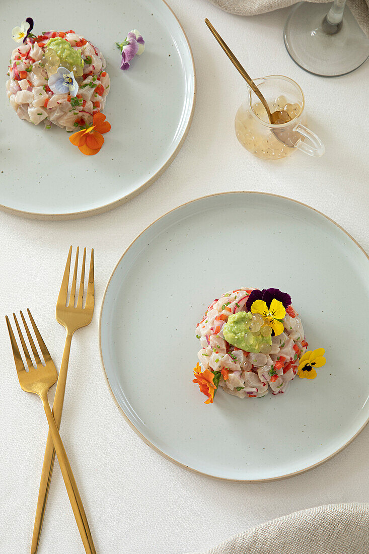 Kingfish tartare with edible flowers in a restaurant