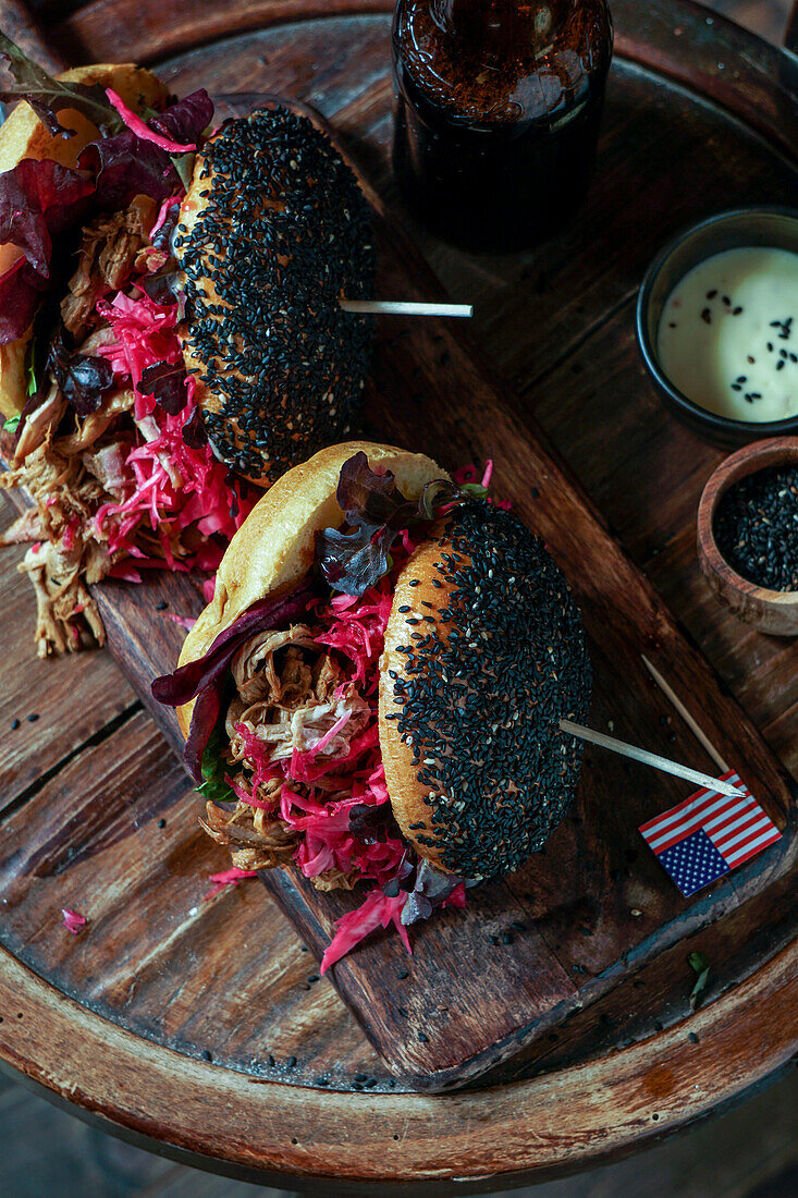 Pulled pork burger with black sesame seeds with crispy apple salad, pickled red cabbage, crispy apple salad, American flag, USA Independence Day