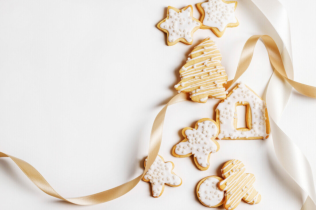 Christmas biscuits with icing on a white background with a bow