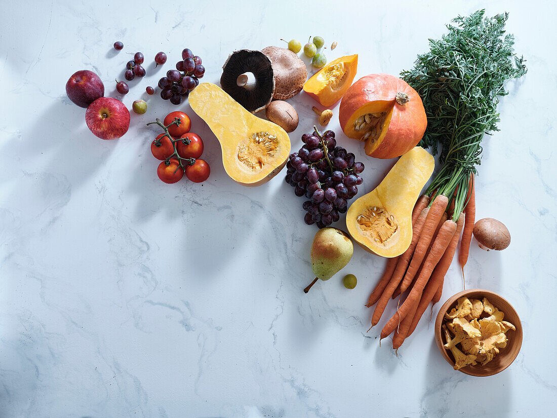 Gesundes vegetarisches Essen der Saison. Flache Platte mit Herbstgemüse, Obst und Pilzen vom örtlichen Markt mit Textfeld. Vegane Zutaten