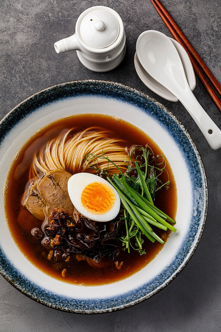 Ramen, Asian noodles in broth with beef tongue, mushrooms and eggs in a bowl