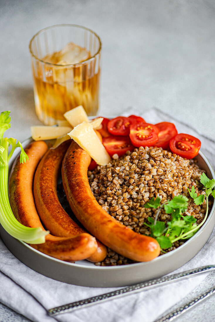 Healthy lunch bowl with buckwheat and sausages served on the table