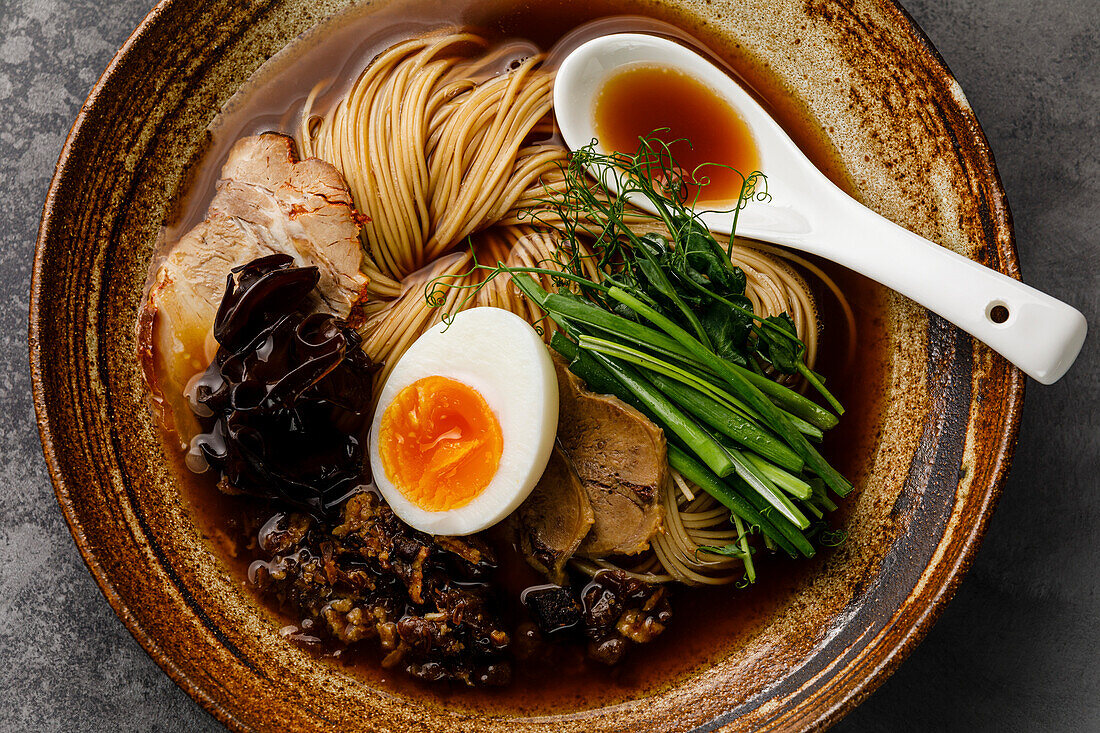 Ramen, asiatische Nudeln in Brühe mit Rinderzunge, Pilzen und Eiern in einer Schüssel