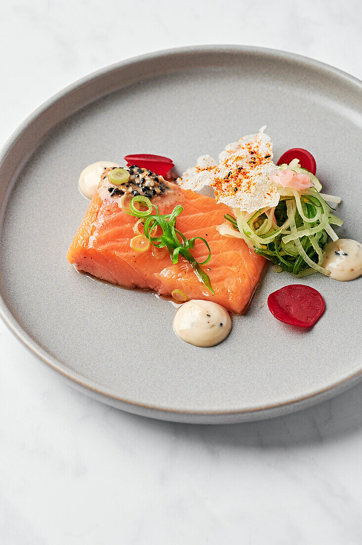 Konfierter Lachs, Sesam-Schwarzpfeffersauce, japanischer Salat, Ingwer-Yuzu-Dressing, Togarashi-Reispapier-Crisp