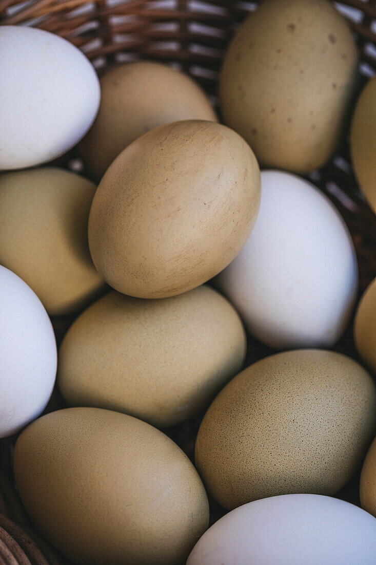 Green eggs in a wicker basket on a white marble table