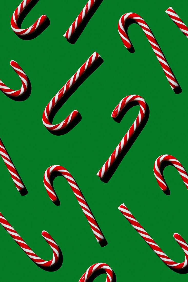 Pattern of Christmas candies cane stick on green background