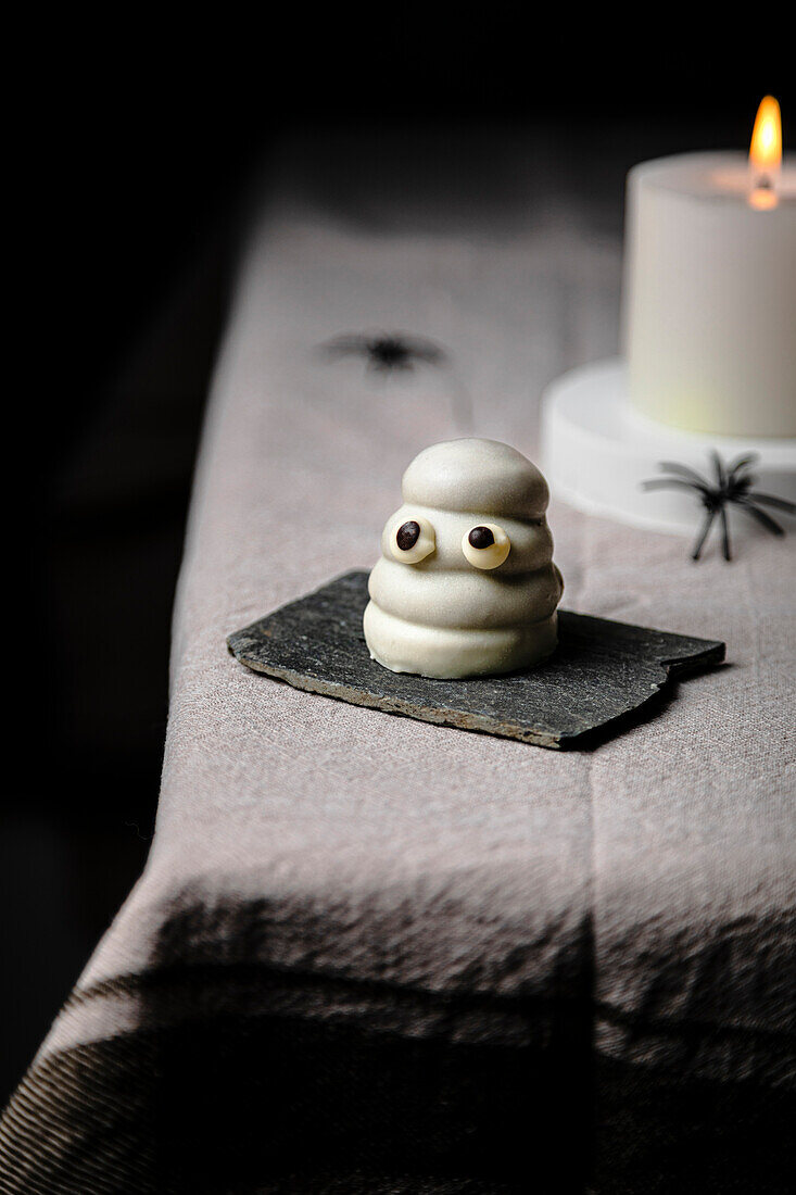 Ghost sweet over table for Halloween; made with cookie, dulce de leche and white chocolate coating