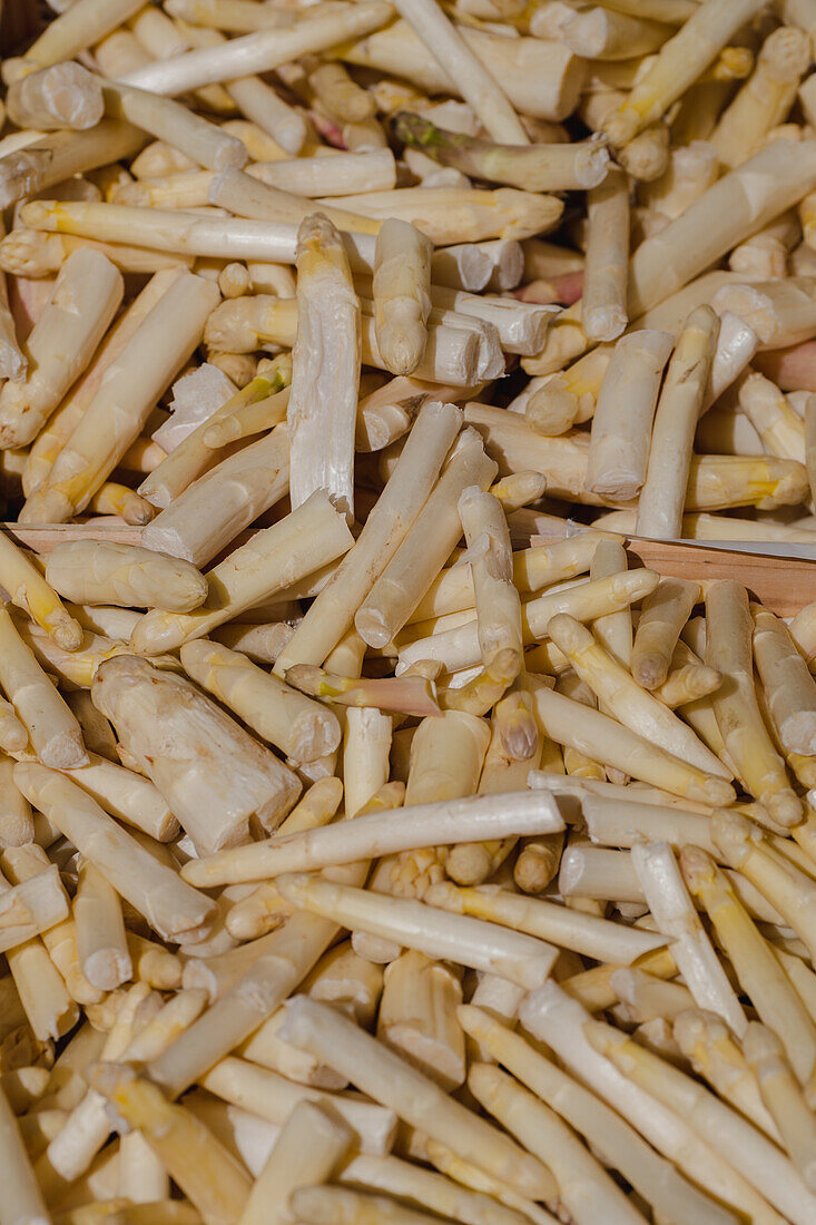 View from above of a pile of fresh, flavoursome roots of spicy horseradish at a stall in a local food market