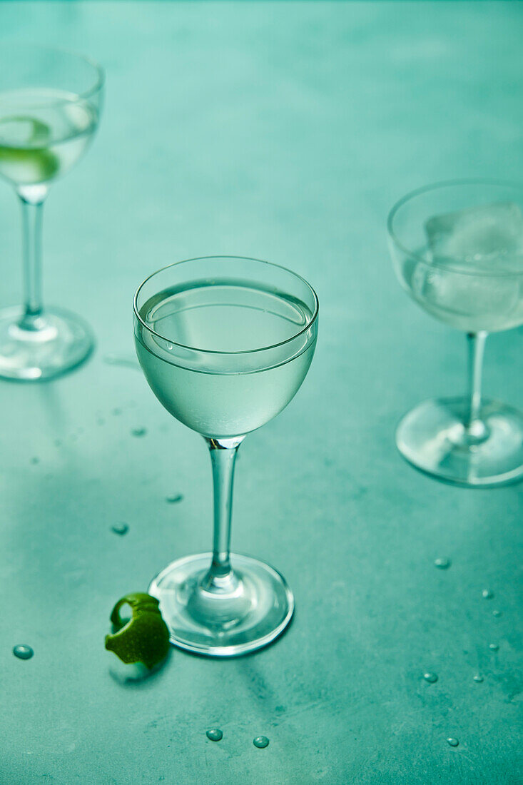 Dry martini with lime on sage green background