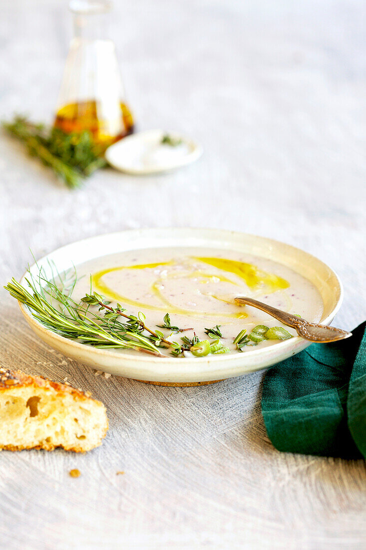 Purple potato and fennel bisque on a white table