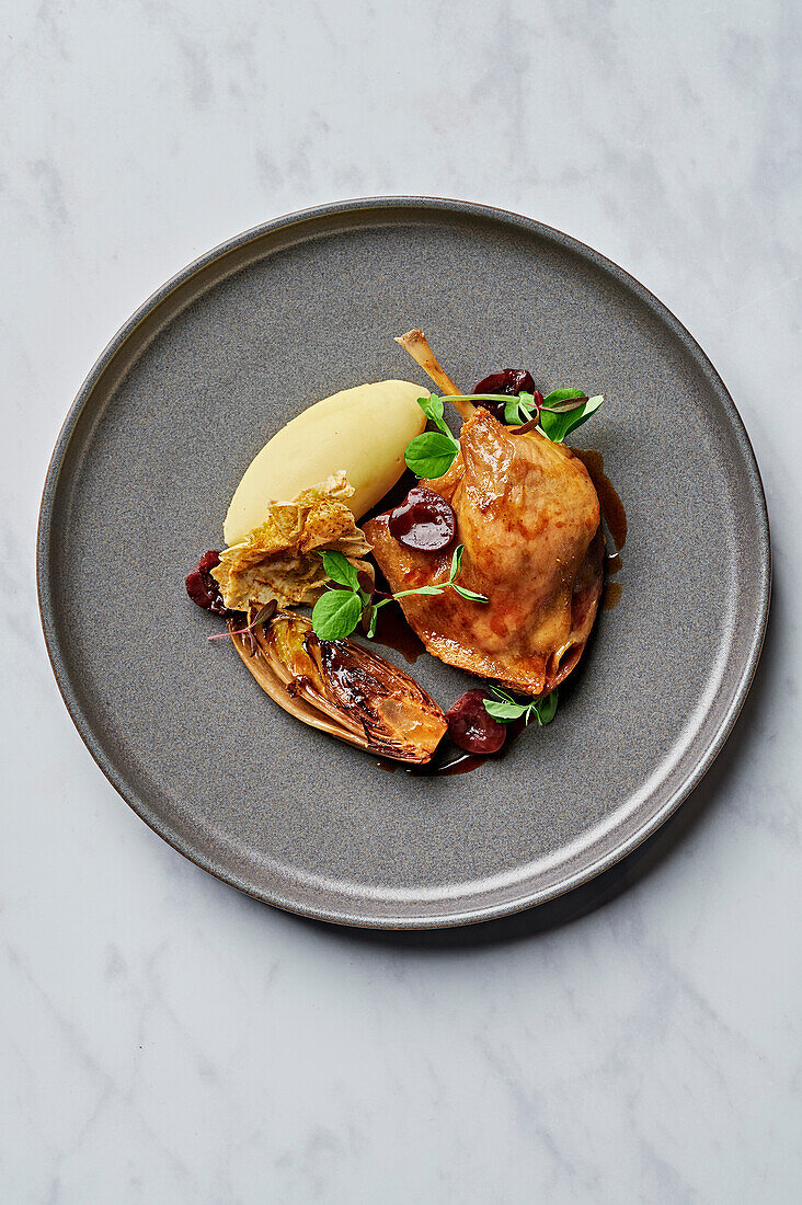 Confit duck leg, creamy puree, caramelised chicory, sour cherry jus, filo waffle dusted with pistachios