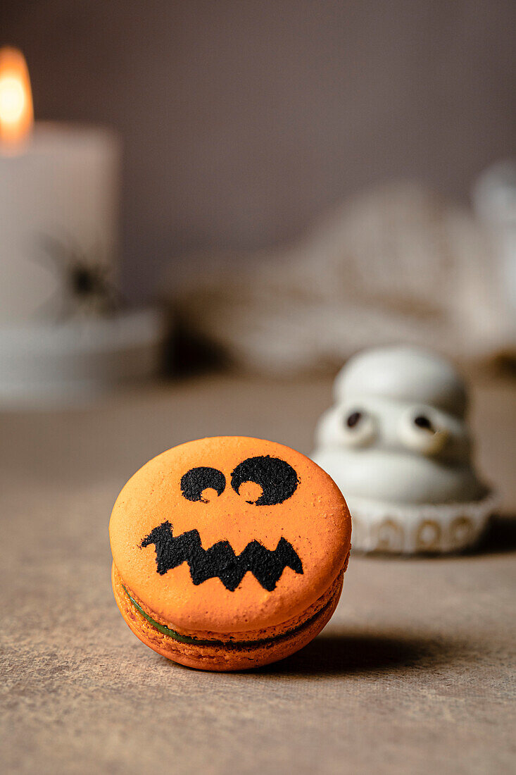 Jack-o-Lantern macaron over table for Halloween