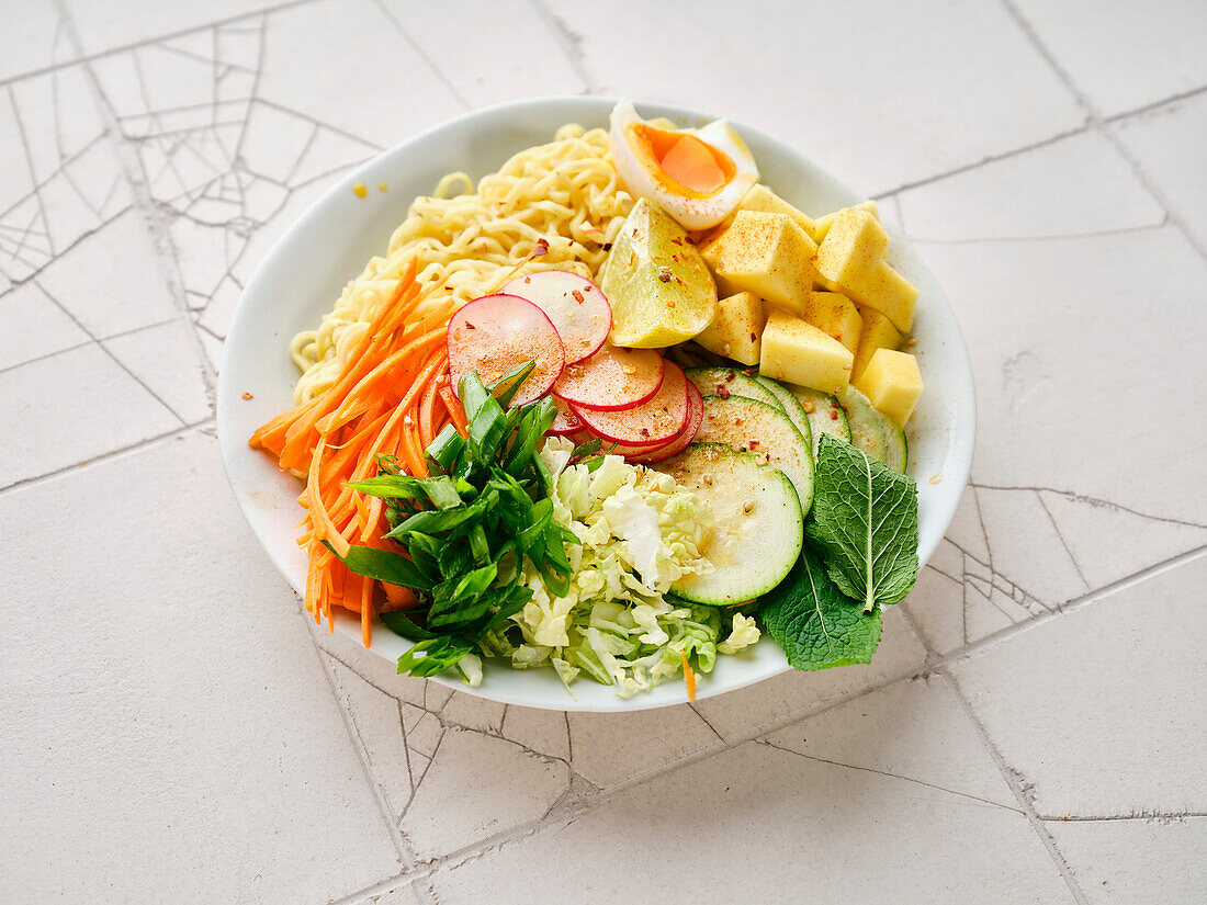Salad ramen - vegetarian dish with egg noodles, mango, lime and vegetables. Healthy panasian cuisine