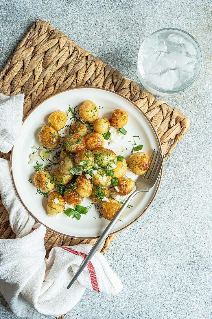 Top roasted spring potato vegetables with herbs, served in a bowl for lunch