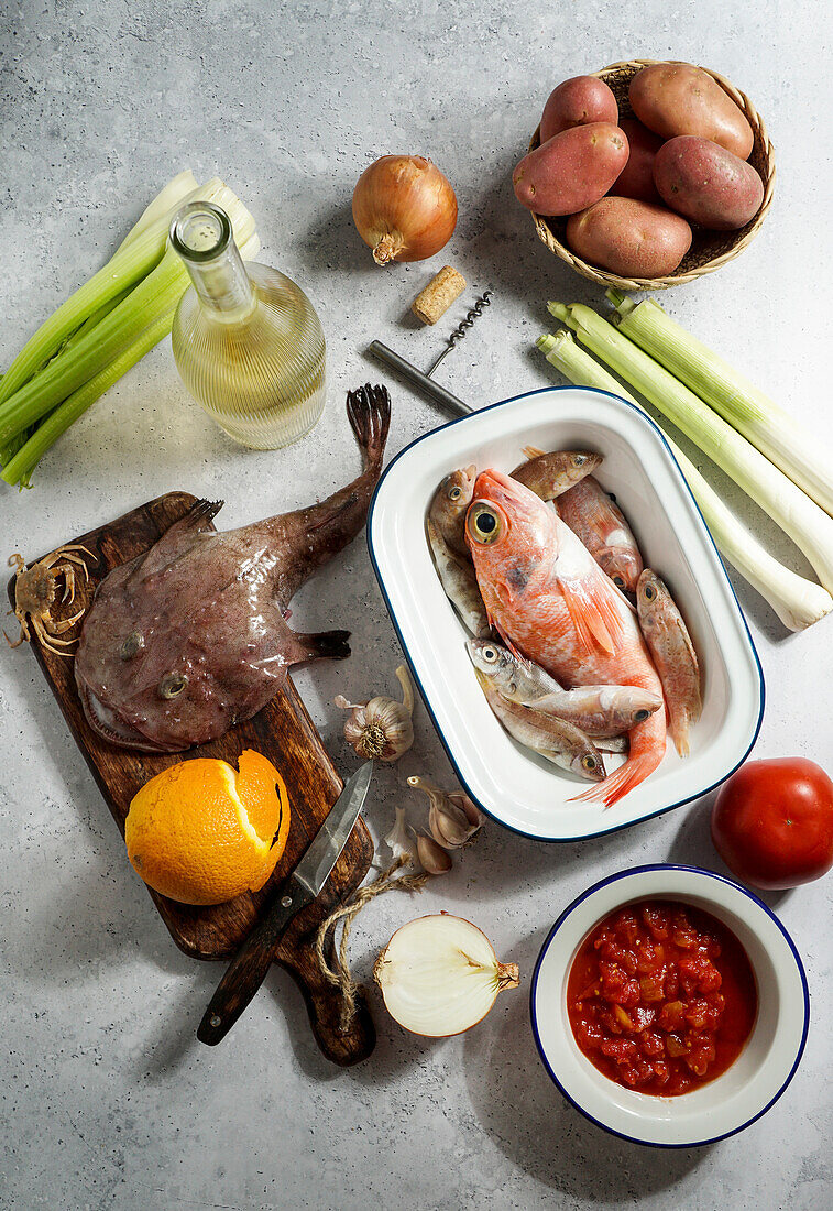 ingredients for french soup Bouillabaisse with devil fish, Sebastes, with tomatoes and white wine, top view