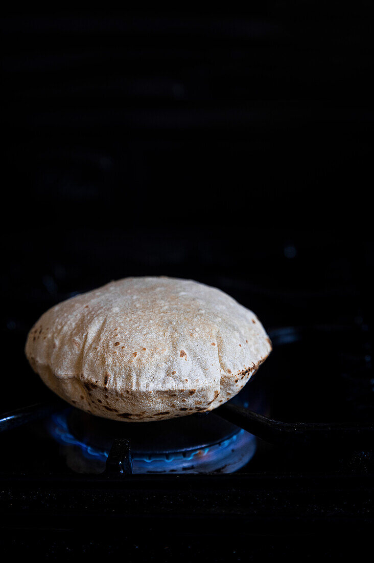 Phulka Roti auf der Flamme gekocht