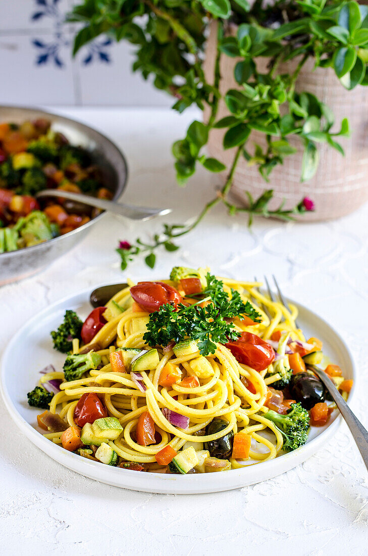 Spaghetti with crunchy vegetables and turmeric on a plate