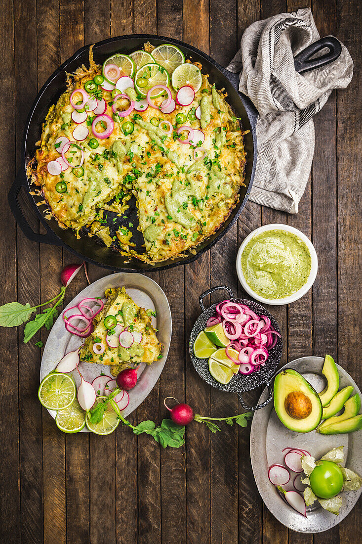Mexican casserole in cast iron pan with toppings and avocado