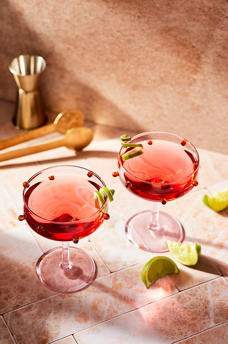 Ein Cosmopolitan-Cocktail in einem traditionellen Glas auf einer rosa Bar