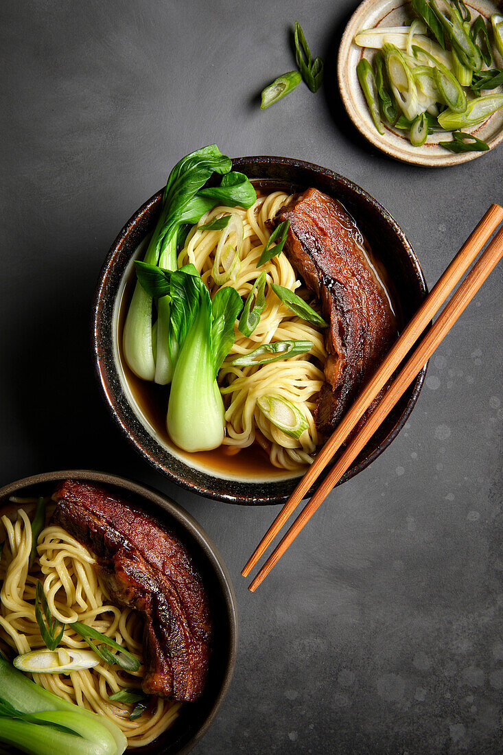 Ramen, Schweinebauch und Bok Choy mit schwarzem Hintergrund