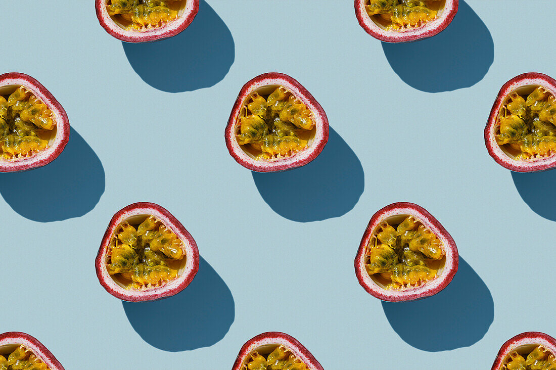 Horizontales Muster von tropischen exotischen Passionsfrüchten auf blauem Hintergrund flatlay Lebensmittel