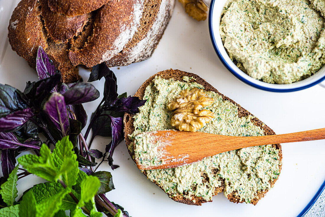 Healthy rye bread and walnut sauce on a chopping board from above