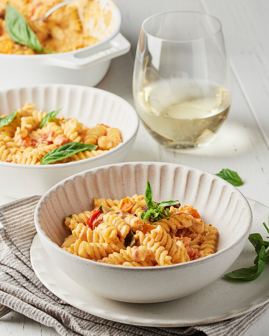 Zwei Schalen mit cremiger Tomatennudel mit Basilikum und Weißwein