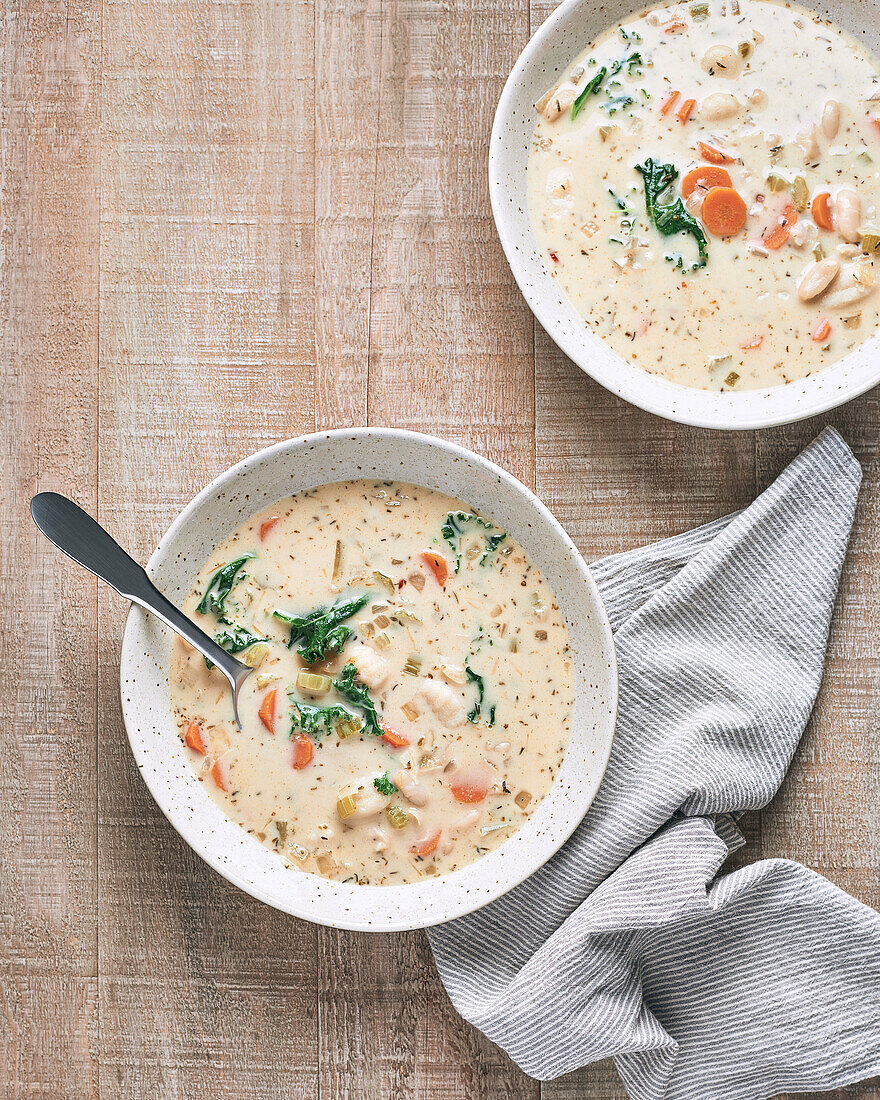 Two Bowls of Vegan Gnocchi Soup on Wood Background