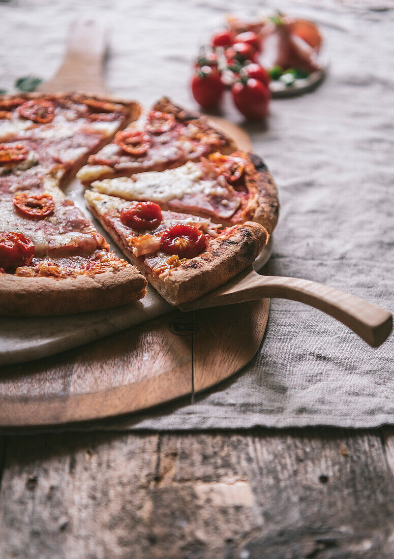 Schinken-Mozzarella-Pizza auf einem Schneidebrett