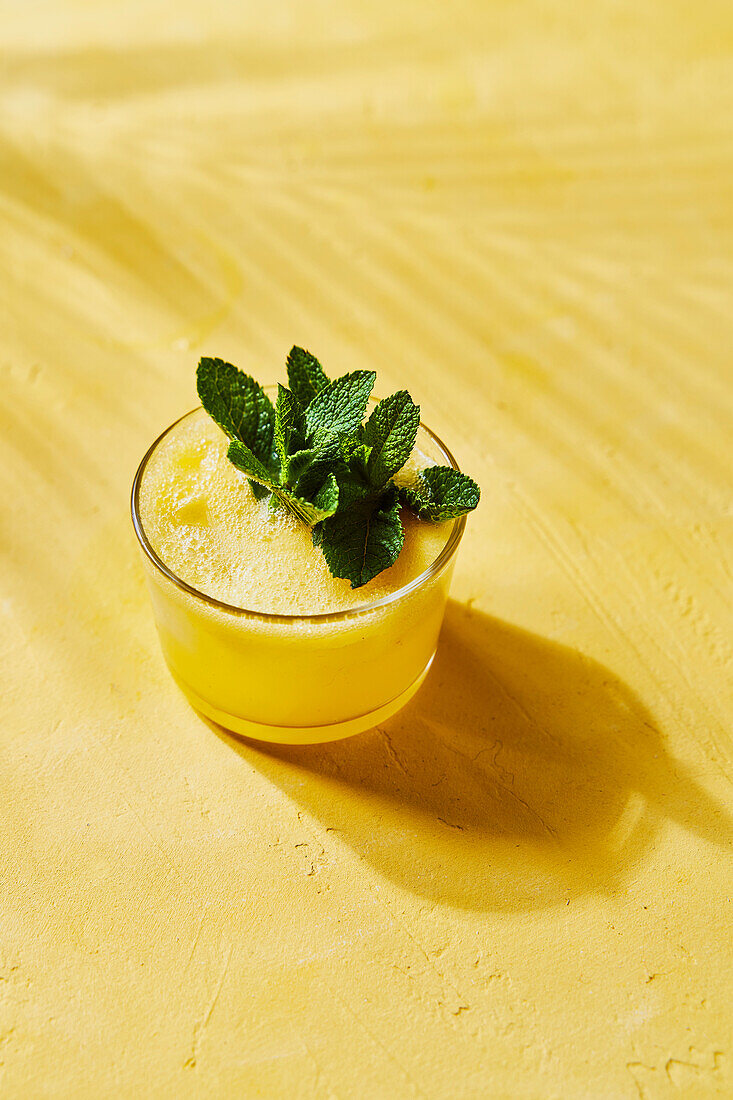 Pineapple and mint G&T on a yellow background with shade