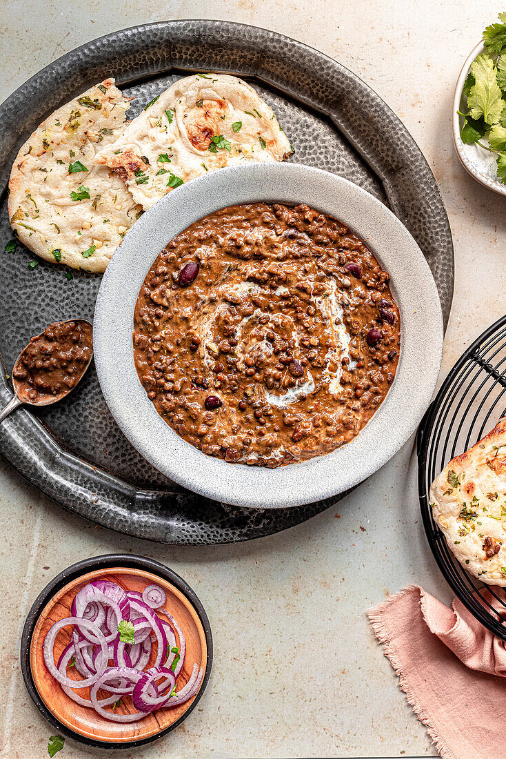 Dal Makhani served with naan bread and onion salad