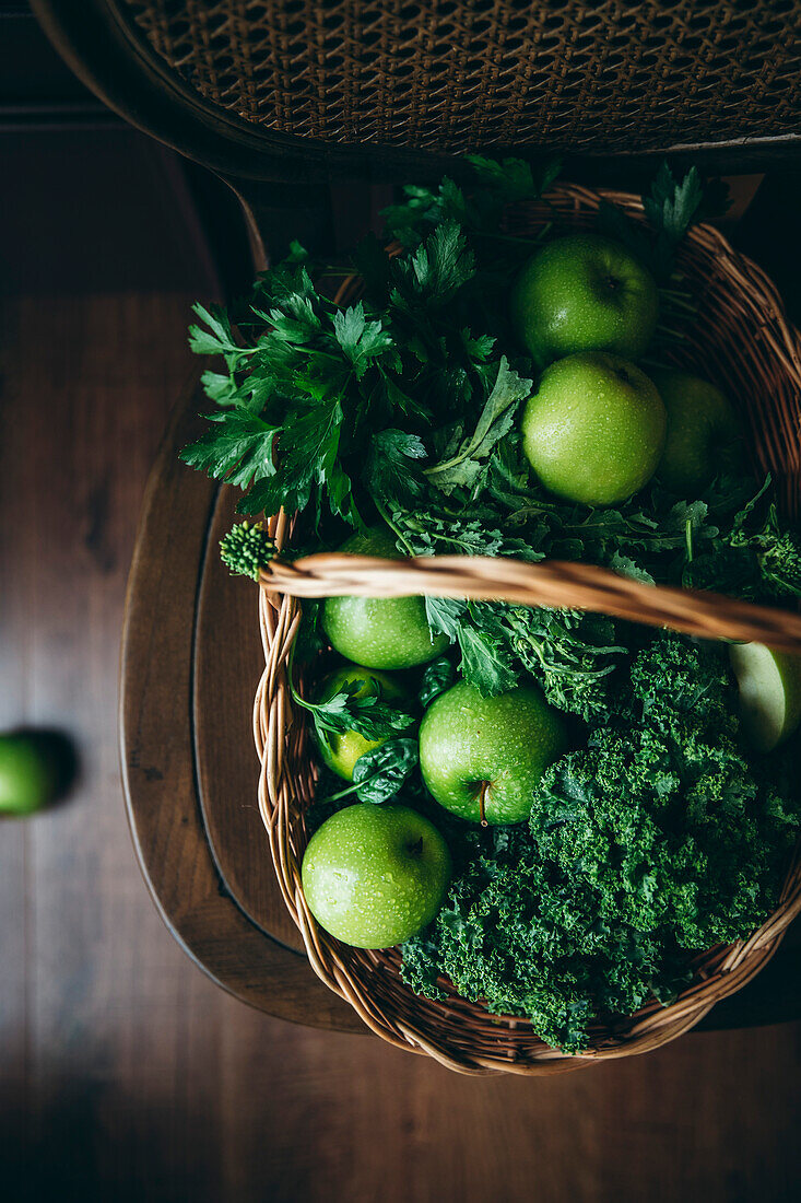 Eine Auswahl an gesunden grünen Lebensmitteln, darunter Äpfel und Grünkohl
