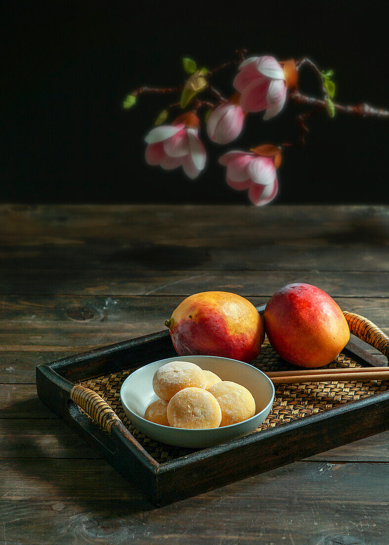 Japanese mango mochi tartlets with ice cream on a classic Asian wooden tray