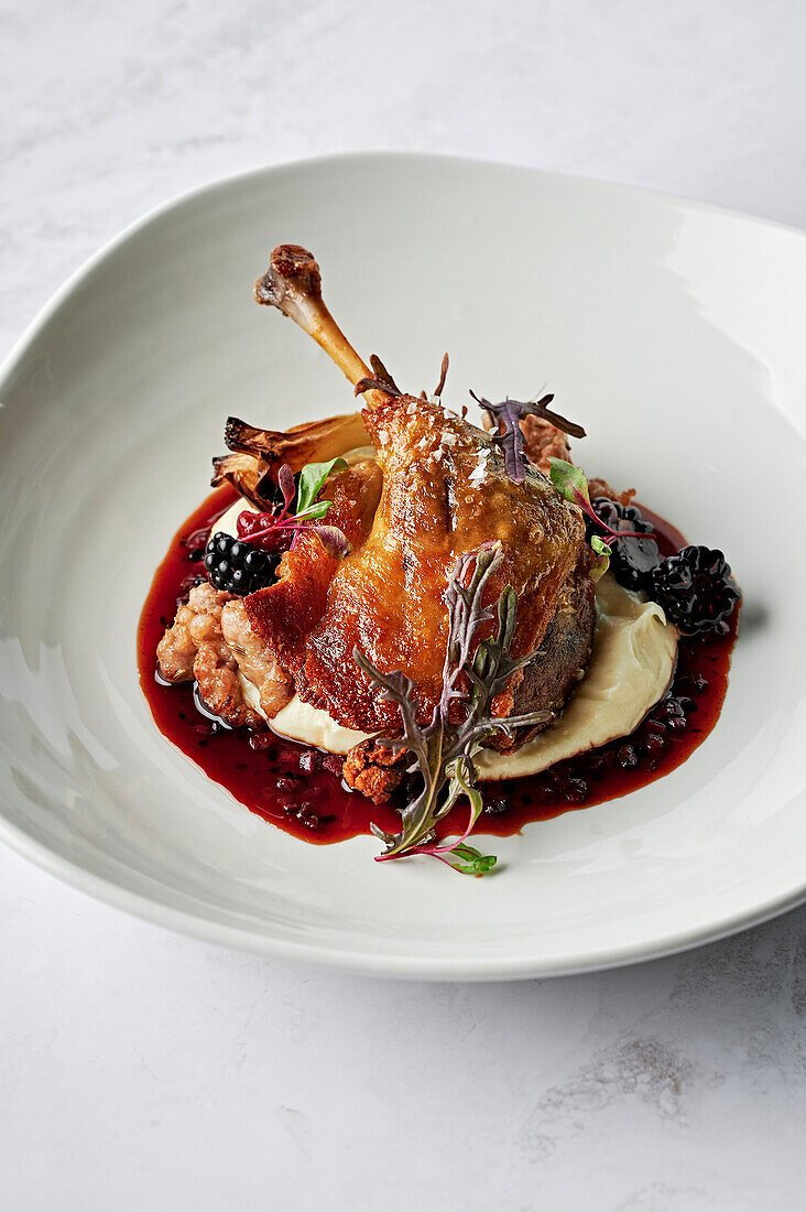 Roasted, confit duck leg, parsnip puree, chipolata of spiced pork and fennel seeds, roasted fennel bulb, duck jus, boysenberries