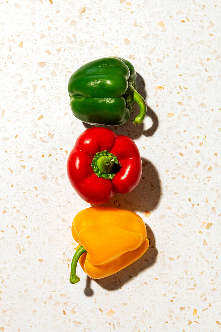 Rote, orange und grüne Paprika auf dem Tisch
