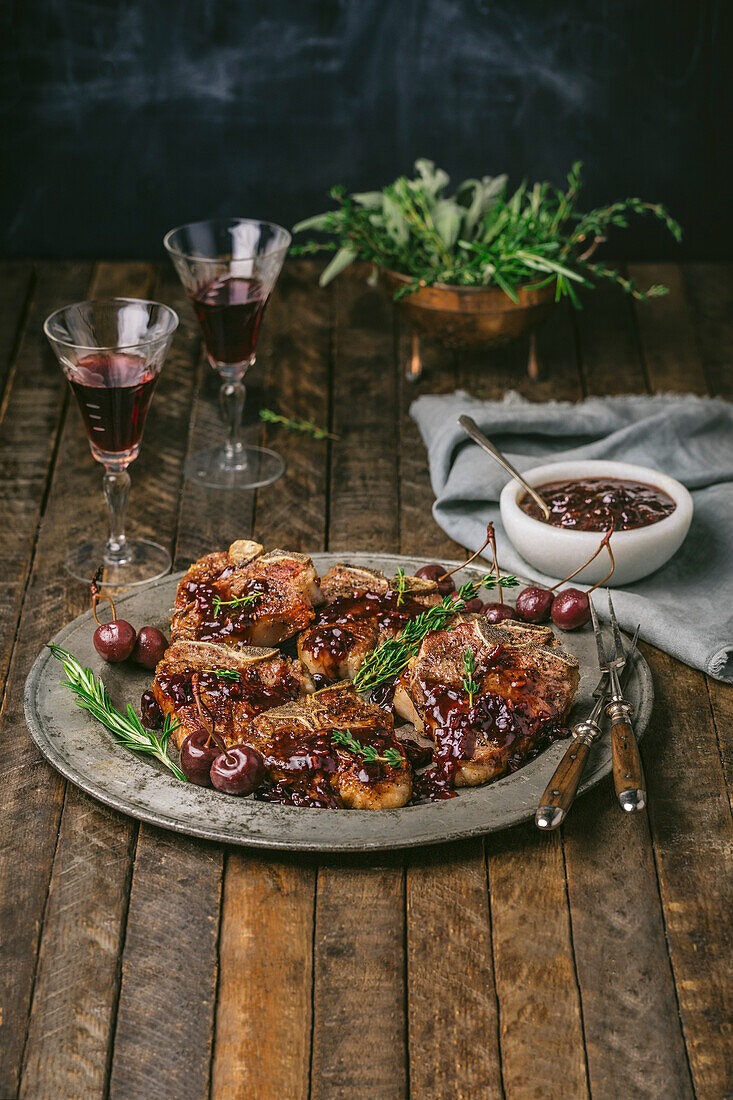 Lamb chops on a pewter plate, with cherry port sauce and port glasses