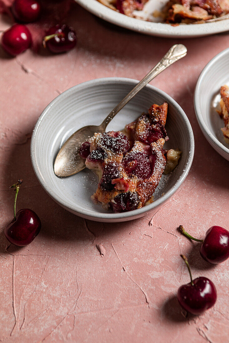 Kirschen-Clafoutis auf rosa Hintergrund