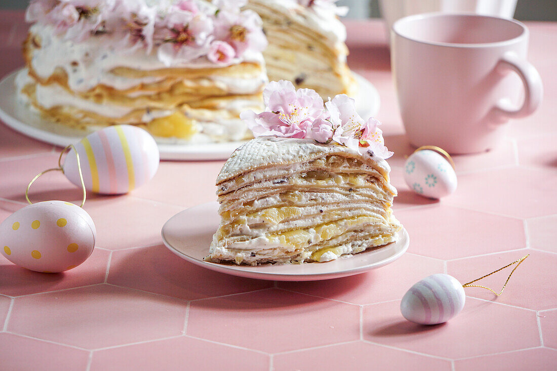 Crepe cake or blini cake for Easter celebrations, pink background, almond blossoms