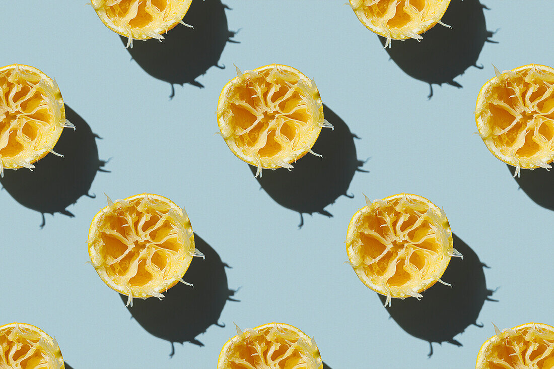 Horizontal pattern of a squeezed juicy lemon after preparing a fresh smoothie drink on a green background Flatlay Food