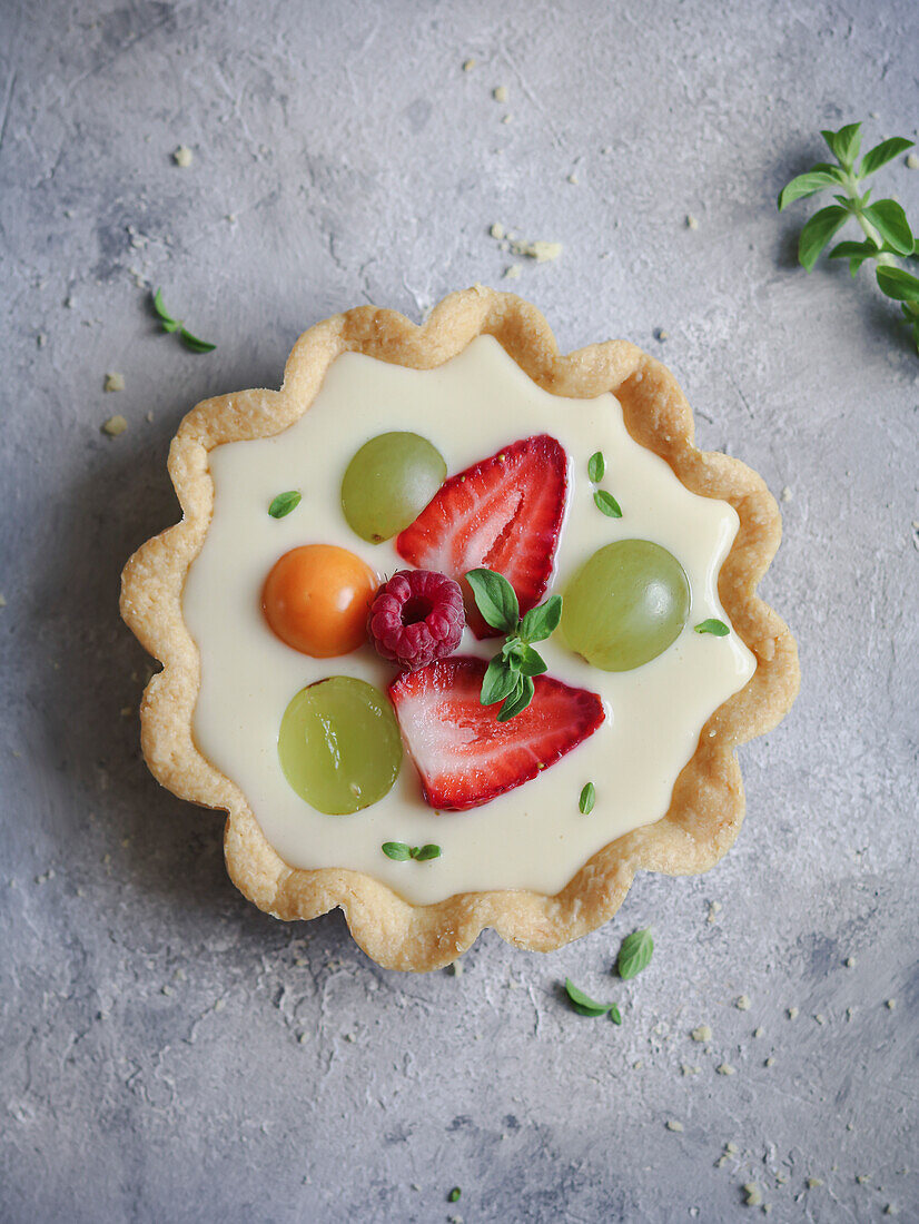 Fresh fruit and custard cream cake decorated with mint leaves